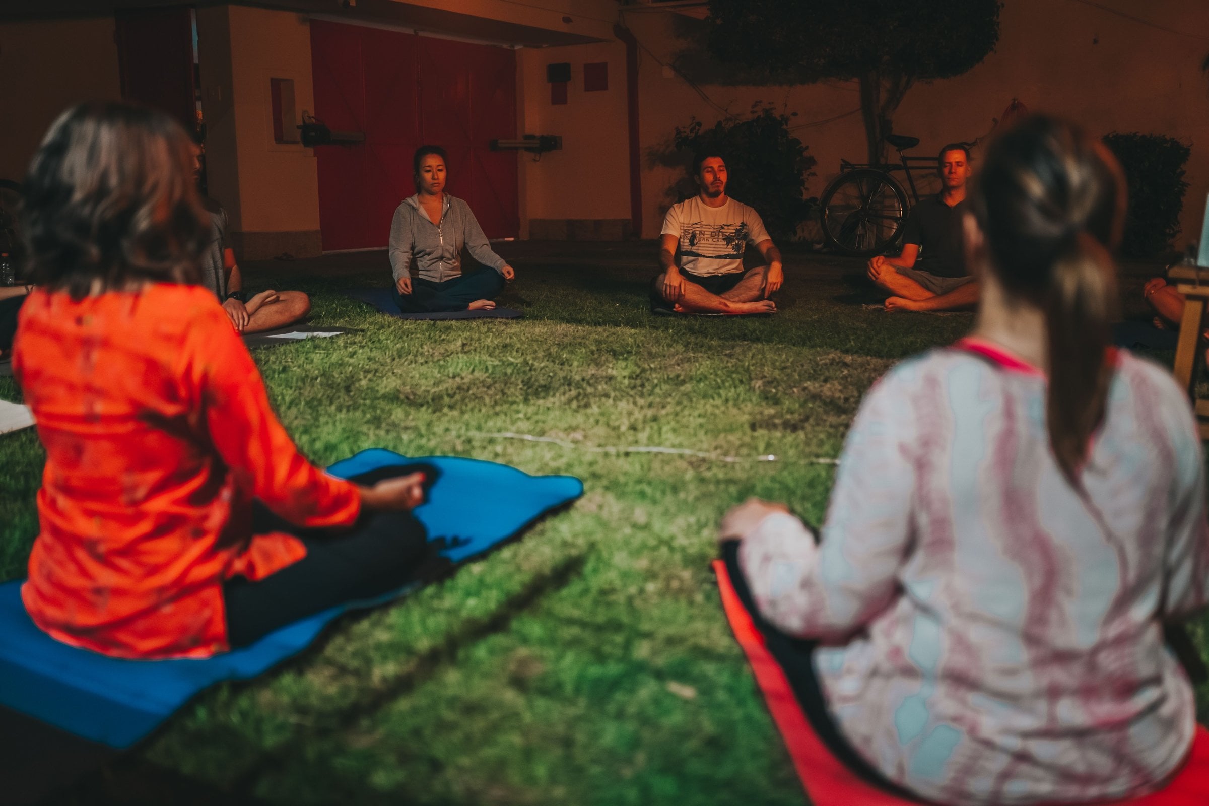 Des personnes assises en cercle sur l’herbe.