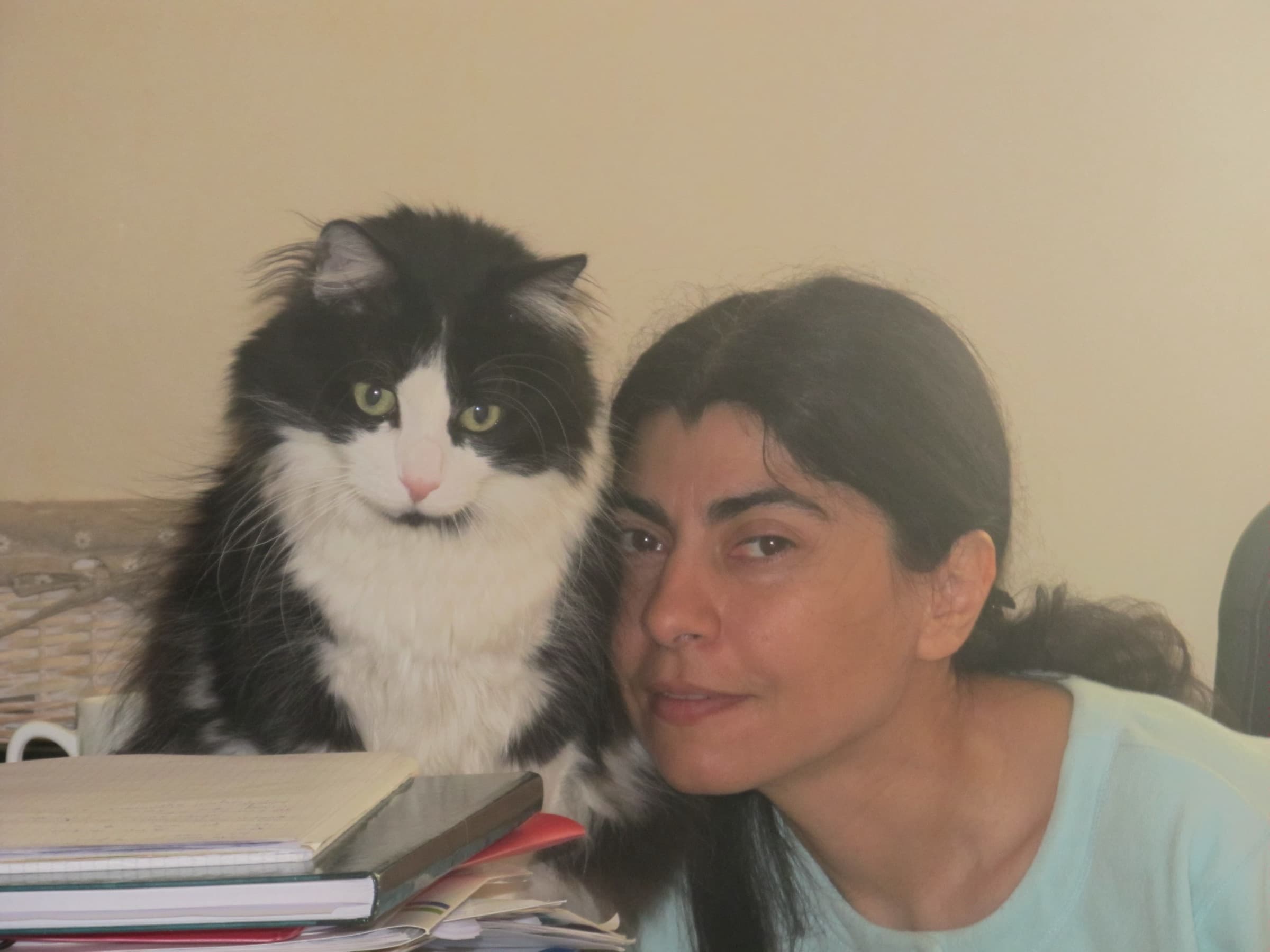 Sandrine Poquet, joue contre joue avec son chat noir et blanc.